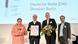 In the picture, four people, two of whom are the winners of the Inclusion Award, stand next to each other and look happily straight into the camera.